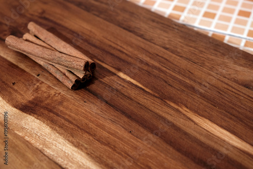 Εκτύπωση καμβά Cinnamon sticks rest on rich, warm-toned wooden surface