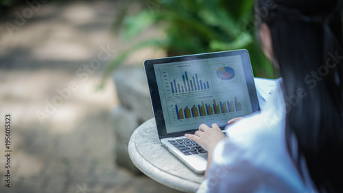Konstfotografi Outdoor Data Analysis: A person engrossed in data analysis on a laptop in an outdoor setting, symbolizing work-life balance and modern business strategies