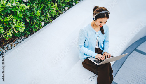 Beautiful young adult business asian woman hand typing keyboard looking at laptop freelance work from anywhere modern lifestyles