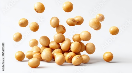 Raw soybeans falling on a pile isolated on white background