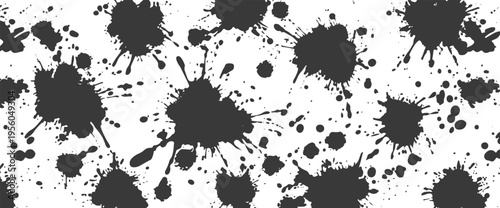 Dark grey ink splatters and paint drops on a white background
