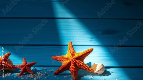 Vibrant orange starfish on blue surface with shells and textured background