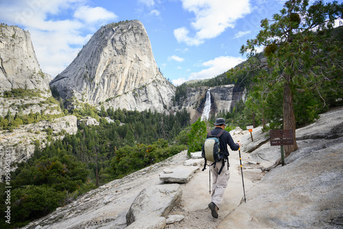 Man hiking John Muir trail towards Vernal Falls. Winter detour as Mist Trail is closed. Yosemite National Park. California. USA.