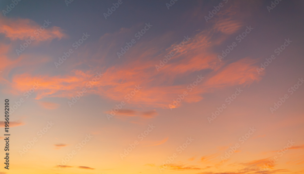 Fototapeta premium Beautiful Sunset Sky with Soft Clouds and Colorful Twilight Gradient,A breathtaking view of the evening sky during sunset, featuring a vibrant gradient of orange, yellow, and blue hues with scattered 