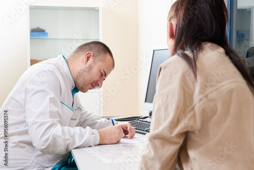 Photography Young male doctor examining and consulting young female patient in hospital clinic
