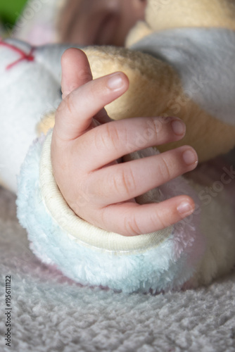 Close up of newborn baby hand resting on soft blanket, innocence and tenderness concept