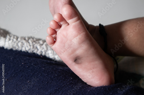 Close up of newborn baby feet resting on soft blanket, innocence and childcare concept