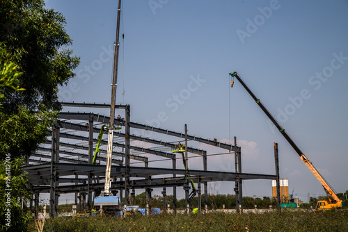 Canvas Print Large Steel-Frame Warehouse Structure Under Construction with Crane and Worker,C