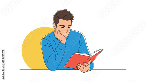 Young man sitting at a table and deeply engrossed in reading a book for education or leisure against a simple background.