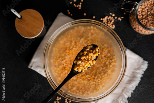 Bowl of yellow dried split peas on dark background. Yellow soaked peas. High quality photo