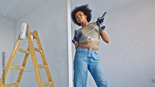 Foto A confident woman of african descent is actively engaged in home improvement tasks