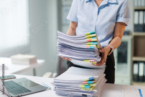 Cuadro en lienzo Businesswoman sorting towering stacks of financial reports and administrative fi