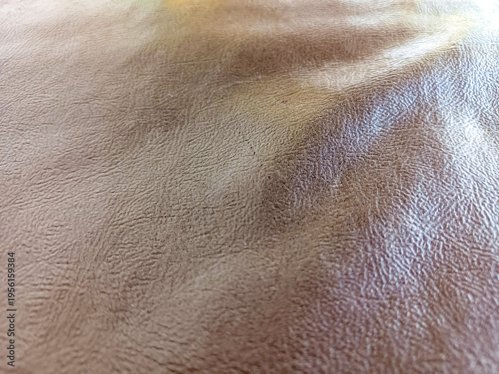 Fototapeta premium Abstract brown faux leather texture background with ripples. Dark leather surface with large copy space for text and luxury brand placement.