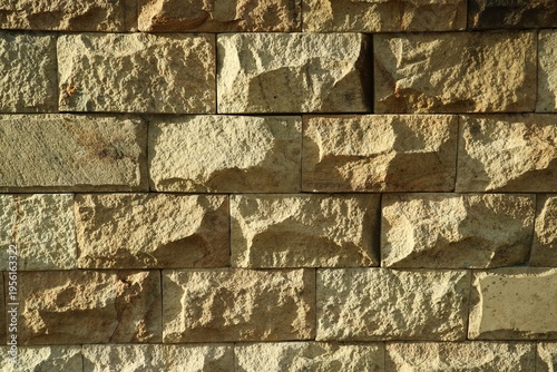 Foto A close-up photo of a natural stone wall with a rough texture and a brownish-yellow color