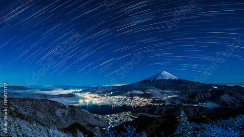 Composite image of Mt. Fuji and star trails over Lake Kawaguchiko at night.