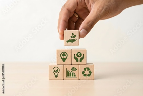 Hand places a wooden block with a green plant icon, symbolizing growth, on a pyramid of sustainability and environmental management concept blocks.