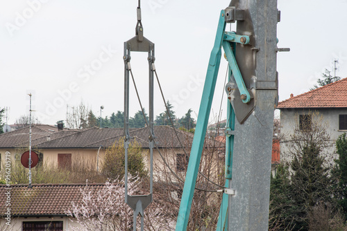 Tower crane lifting construction materials on building site against blue sky, urban development concept