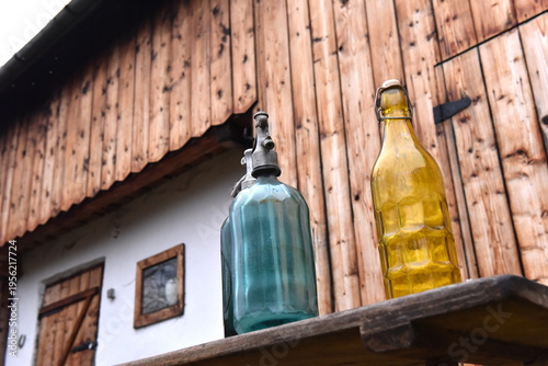Photography Vintage glass soda siphons and yellow bottle on rustic wooden bench