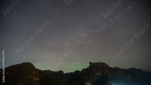 An awe-inspiring image showcases a dark sky densely packed with stars, with mountains casting silhouetted against the horizon.