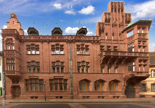 Ornate historic building in Freiburg im Breisgau with red stone facade decorative windows balconies and detailed architectural elements along a quiet city street