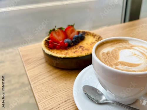 Delicious crème brûlée with golden caramel crust and berry garnish, creamy texture visible, stylish dessert on wooden background.