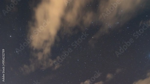 A celestial canvas of stars shimmer through the ethereal veil of clouds, evoking a sense of wonder and the vastness of space. 