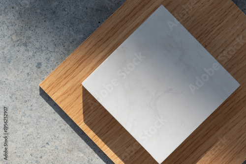 An aesthetic arrangement of interior design material samples featuring light and warm wood grain textures paired with a central white marble or quartz stone swatch.