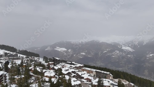 Aerial view of Courchevel ski resort by winter shot with drone on a cloudy day with snowy chalets