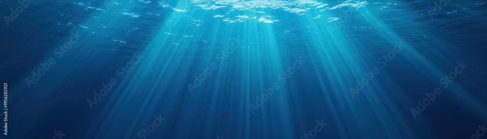 Naklejka premium Underwater scene with bright sunlight rays streaming down through the ocean surface