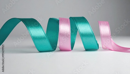 Curled Teal and Pink Satin Ribbons on a White Surface.