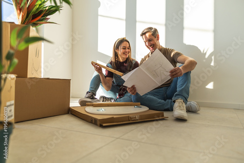 Foto Cheerful Couple Building Furnitures Together