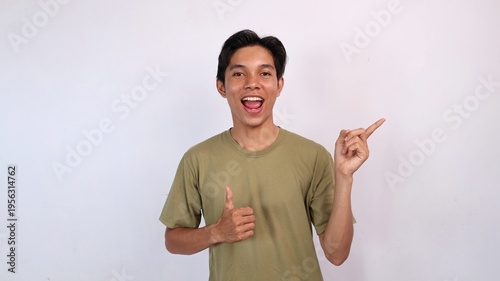 excited young asian man gesturing okay, pointing up