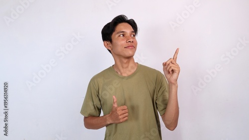 young asian man smiling ok gesture, pointing and looking