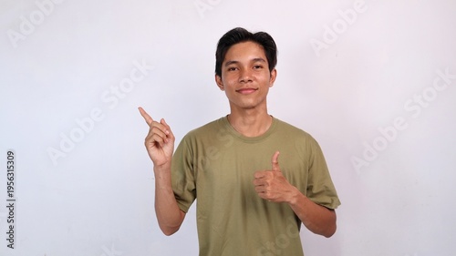 Asian young man smiling okay gesture, pointing to the side