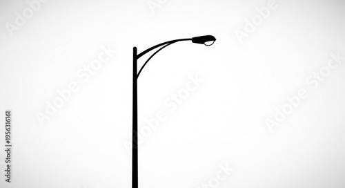 Silhouette of a Streetlight Against a Bright White Sky.