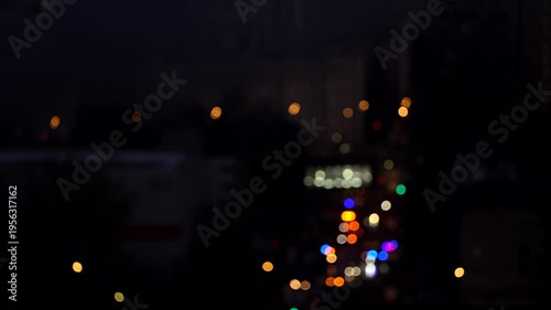 City street at night with colorful bokeh lights, blurred urban lights, atmospheric night scene, abstract city illumination