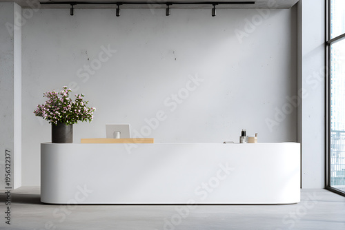 Modern reception area featuring a white curved counter with a minimalist design, flowers, and a monitor. A large window provides natural light