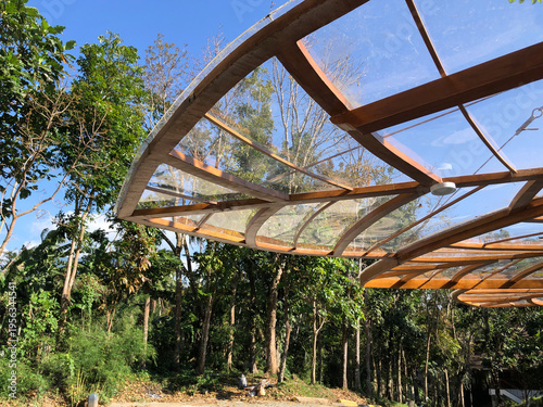glass canopy covers the facade of a building located in a forested nature park.