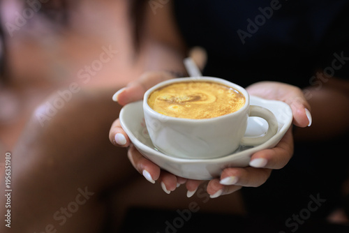Hot Vietnamese Egg Coffee in Cup Held by Young Asian Woman