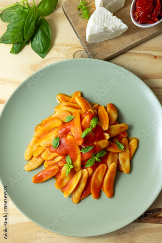 Italian pasta with tomato sauce and basil on green plate, traditional food lifestyle concept
