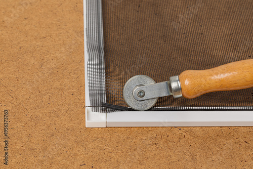 Fotografía Repairing window screen frame with new fiberglass mesh