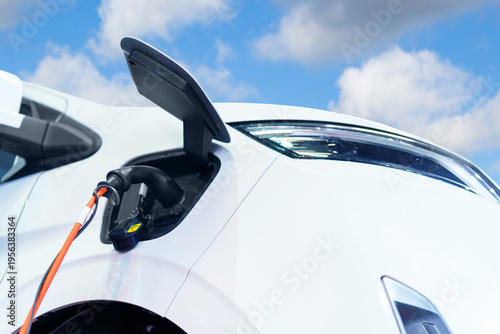 Close up of electric delivery van with connected charging cable
