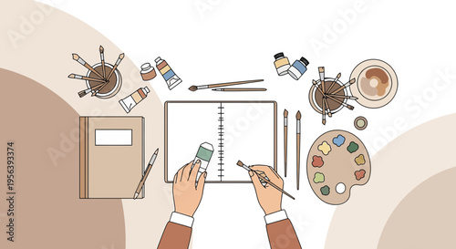 Creative art workspace with sketchpad, paints, brushes, and palette for artistic endeavors