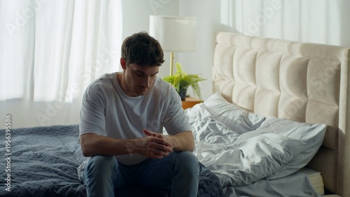 Tablou pe pânză Caucasian man sitting on bed at home holding head grief pain depressed male exha