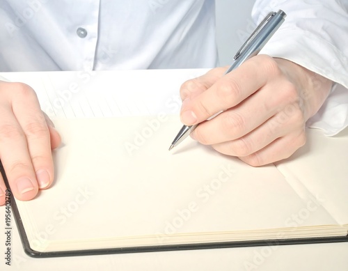 Wallpaper Mural Close-up of a person writing in a notebook with a pen. Torontodigital.ca
