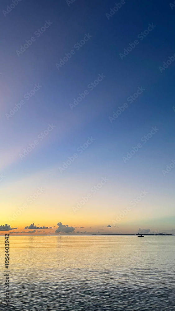 Fototapeta premium 夕暮れの沖縄の海、南国、黄昏時の穏やかな海景色 名嘉真の浜