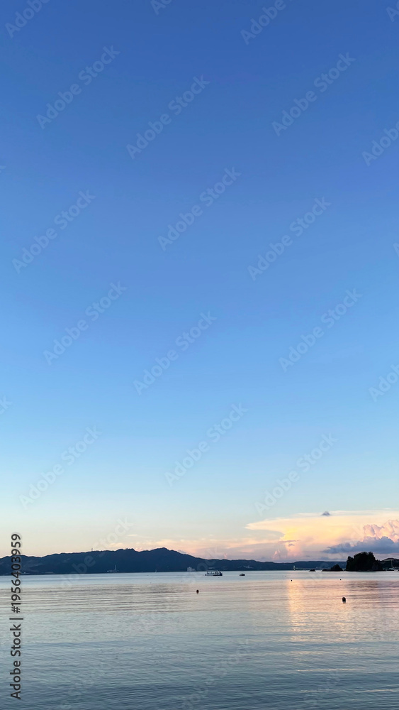 Fototapeta premium 夕暮れの沖縄の海、南国、黄昏時の穏やかな海景色 名嘉真の浜