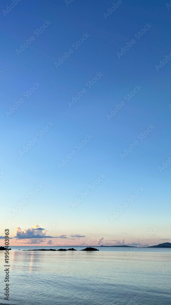 Fototapeta premium 夕暮れの沖縄の海、南国、黄昏時の穏やかな海景色 名嘉真の浜
