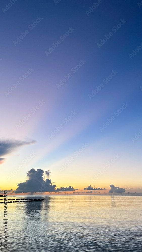Fototapeta premium 夕暮れの沖縄の海、南国、黄昏時の穏やかな海景色 名嘉真の浜