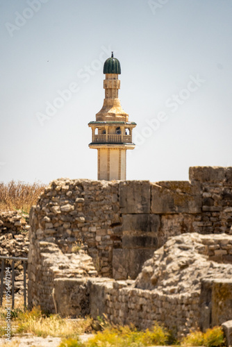 Minaret from a mosque in a nearby village visible above the ruins of Bulla Regia, outside of Jendouba, Tunisia